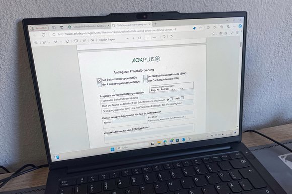 Selbsthilfeförderung 2026: Pauschal- und Projektförderung beantragen Laptop, an dem der AOK-Förderantrag geöffnet ist