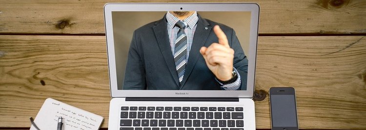 Foto: Laptop mit Mann im Anzug und gestrecktem Zeigefinger nach oben (Quelle: pixabay.com)
